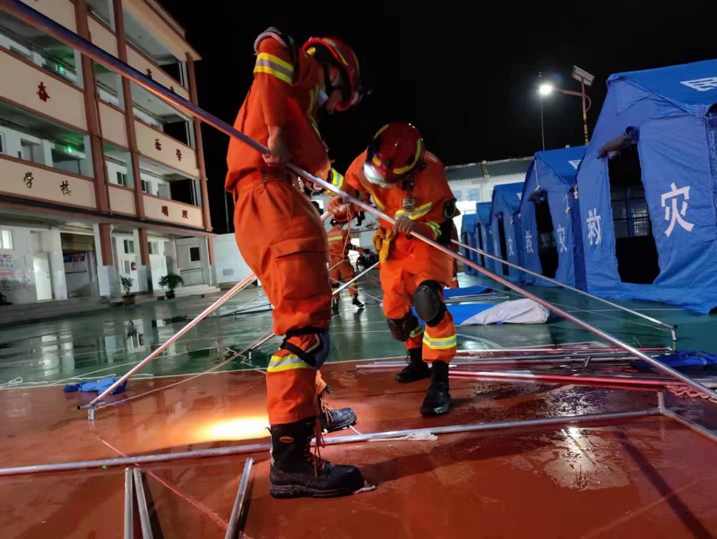 消防人员在双柏县安龙堡中心学校操场上搭建了80顶帐篷。来源:楚雄州消防救援支队