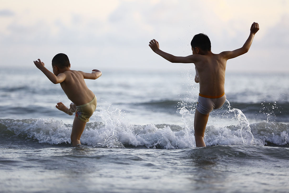 2021年7月11日,海南三亞,小朋友在三亞灣戲水。當日全國各地正式“入伏”,眾多市民遊客親水避暑,戲水享清涼。視覺中國 圖