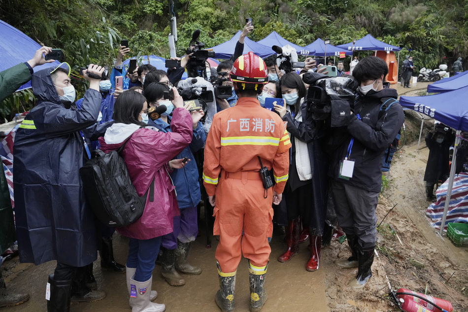 3月24日,广西梧州,一名消防战士在坠机现场附近向媒体简要介绍情况.