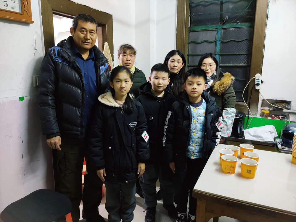 朱泾二小老师到发生火灾的麻文博（前排中）家里进行慰问，为他送上新书包和学习用品 校方供图