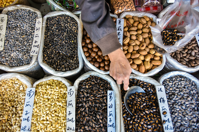 老山东炒货店老板在为顾客称量干货.