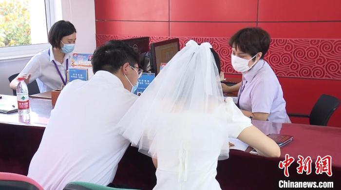资料图：穿着婚纱登记结婚的新人 杨季峰 摄