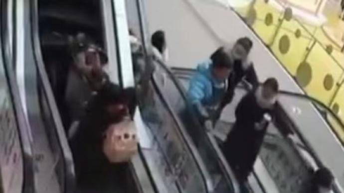 母親推嬰兒車上扶梯摔倒,身后小伙出手相助