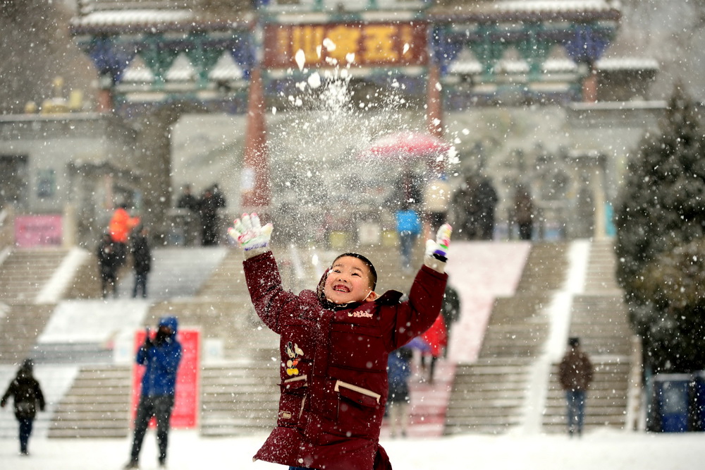1月24日,兰州市降下2021年第一场雪,给兰州平添了一道冬日的风景。孩子们在家长的陪同下在雪地里撒欢。视觉中国 图