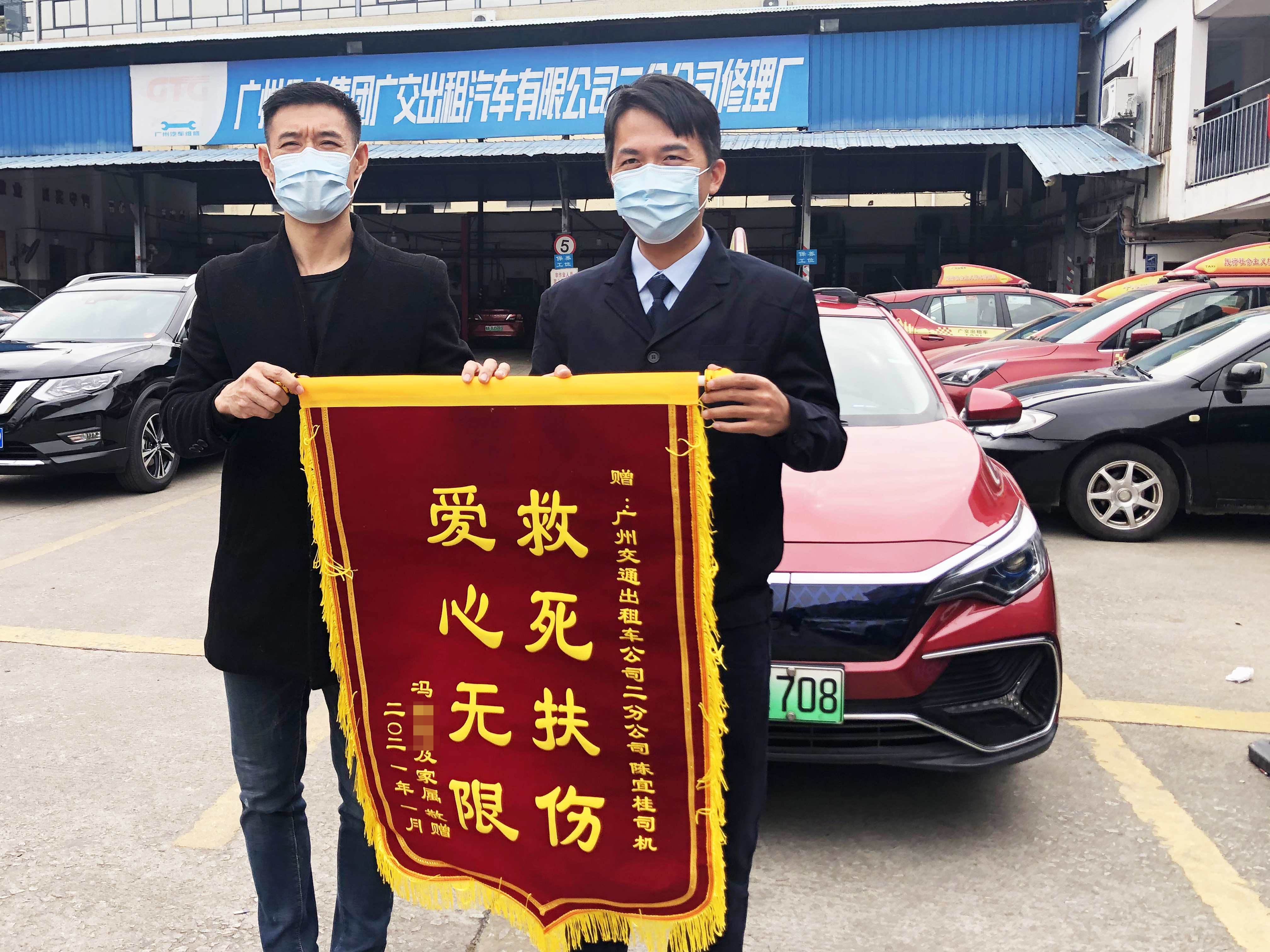 乘客冯先生向的哥陈宜桂(右)赠送锦旗致谢。广州公交集团白云(广交)公司工作人员 供图