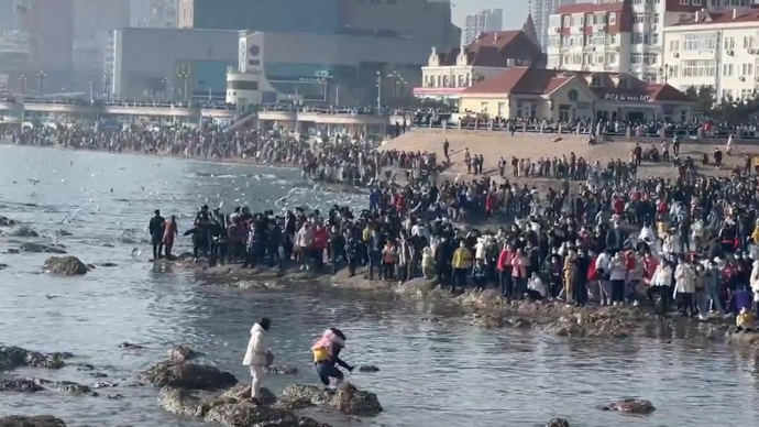 青岛栈桥景区遇涨潮，丈夫蹚水背被困妻儿上岸