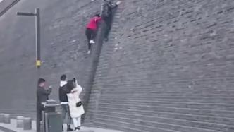 两男子徒手攀爬西安古城墙，同行人员拍照录像