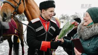 俄罗斯“骑士”向游客赠鲜花，庆祝国际妇女节