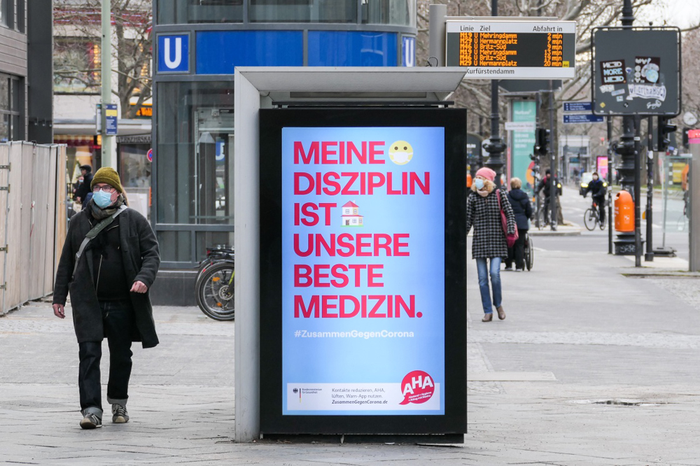 图为一名行人经过写有"我的纪律是我们最好的药物"字样的广告牌.