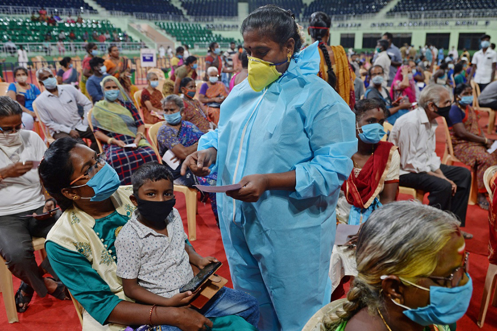 当地时间2021年3月20日,一名医务人员在印度金奈与接种者交谈