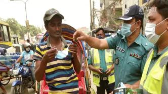 加大防疫措施检查，孟加拉国警方向民众发放口罩