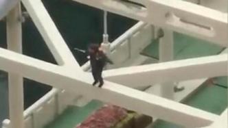 大妈爬上钢架桥顶跳舞，消防员：系环卫工人，疑似精神有问题