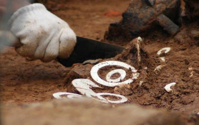 文物考古专家在凌家滩遗址发掘现场清理出土玉器