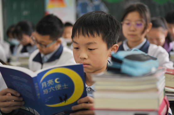 ▲凉山州民族中学学生正在翻阅受赠图书。(摄影:王云)