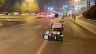 男子骑电动轮椅走机动车道，连续推倒交通锥
