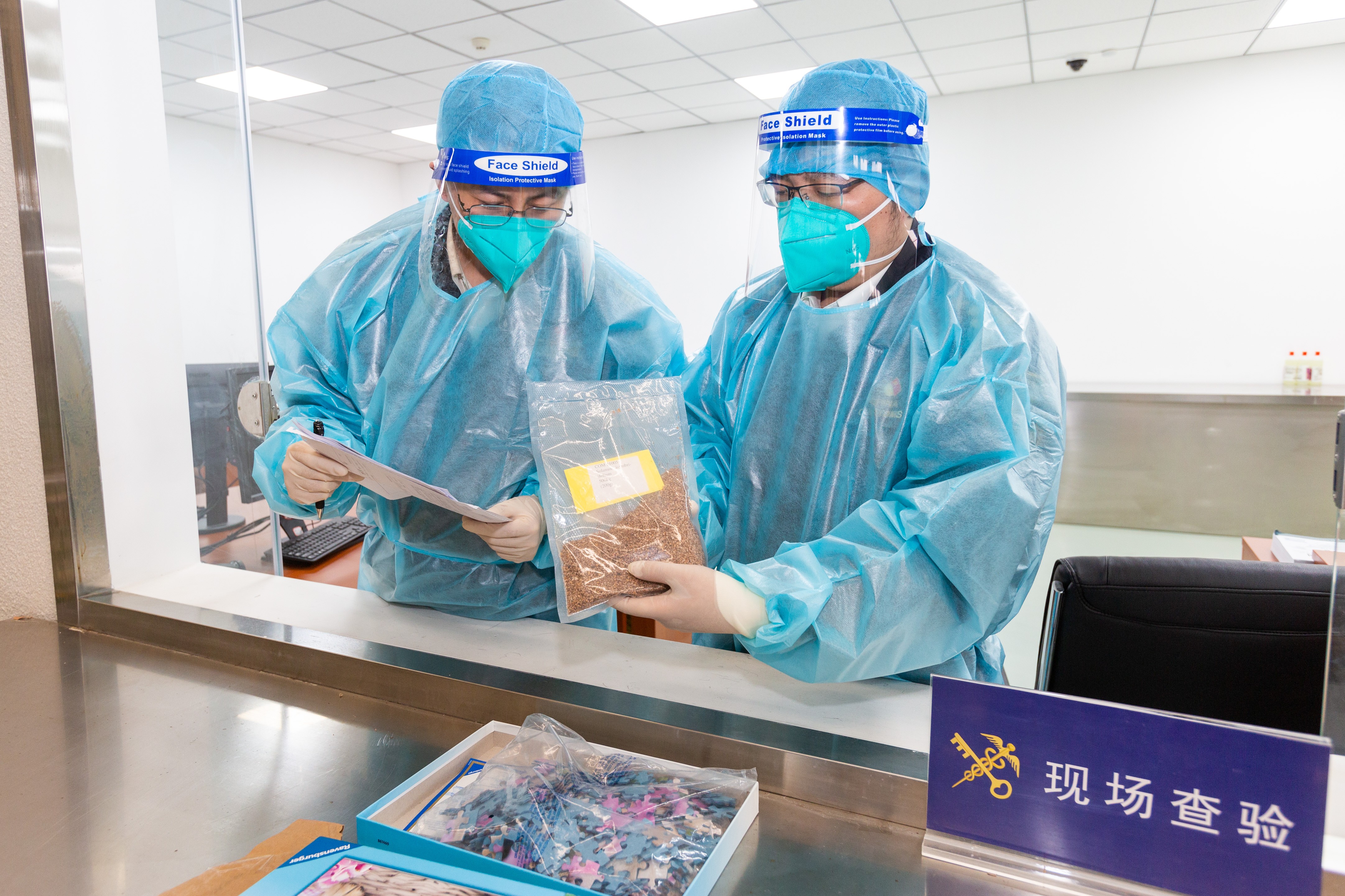 图为北京海关所属首都机场海关关员在装有拼图的快件中查获植物种子0.2千克。(摄影:方星)