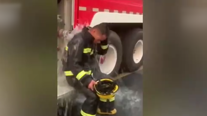 心疼！消防员救火后用余水给自己降温
