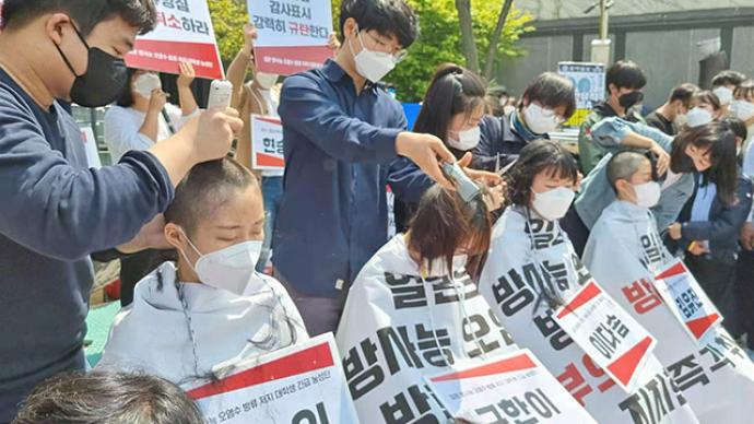 反对日本核废水入海，韩国学生在日本驻韩使馆前削发抗议