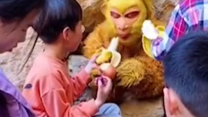 小伙在景区扮孙悟空，游客投喂零食互动