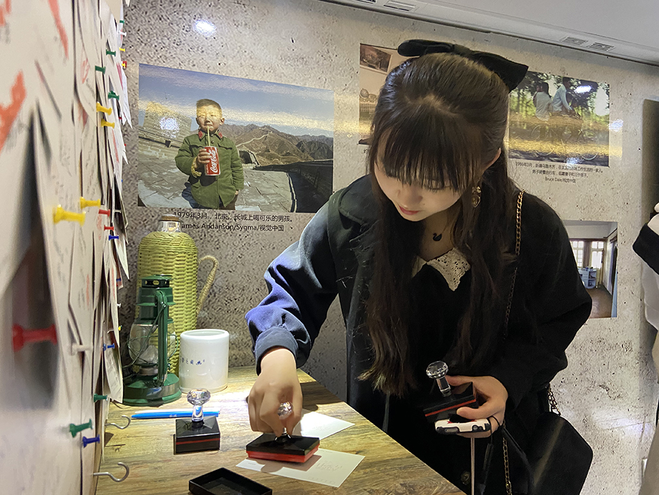 学生在明信片上盖章。