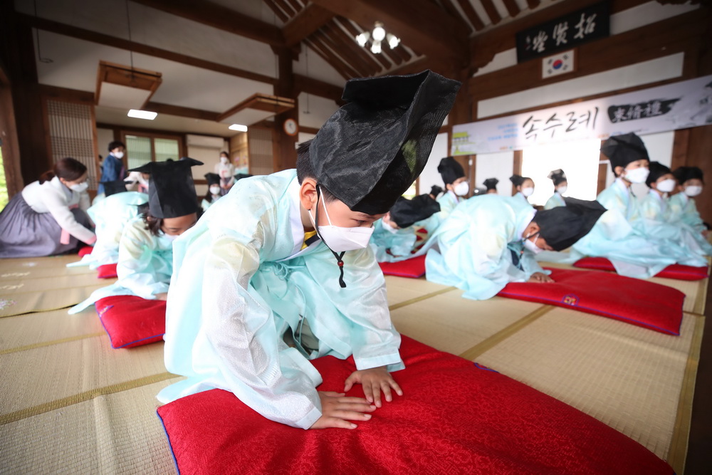 当地时间2021年5月14日,韩国大邱,韩国教师节将至,小学生们穿着传统服装学习束脩礼。束脩礼是古代学生怀着尊敬的心情向老师求教的礼节。