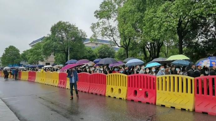 明阳山殡仪馆外市民冒雨排队：手捧鲜花送袁老最后一程