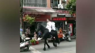 男子身穿白衣骑黑马上街被交警截停：我去给妻子送花