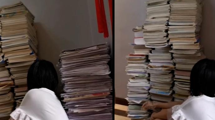 高考結束,女生用過的書籍資料摞起來比人高