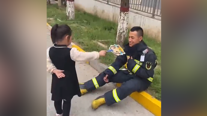 “消防员叔叔热不热”，萌娃为路边休息消防员扇风送水