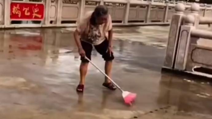 担心孩子们滑倒，104岁奶奶清扫篮球场积水