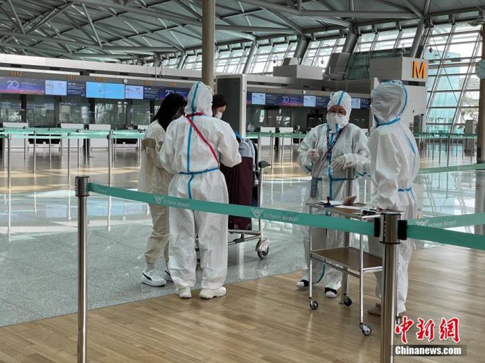 资料图：5月7日，韩国仁川国际机场工作人员严格执行防疫措施。中新社记者 刘旭 摄