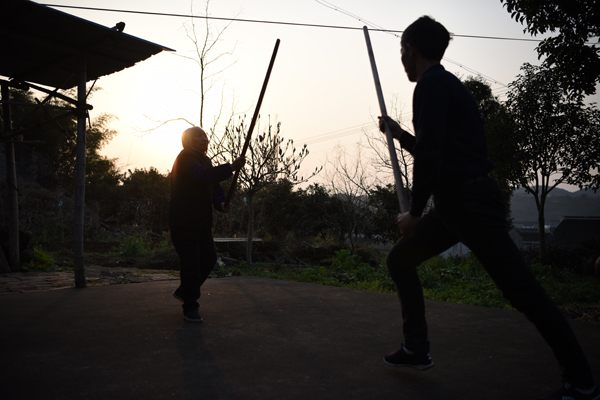 张荷仙老人与儿子进行棍法练习。