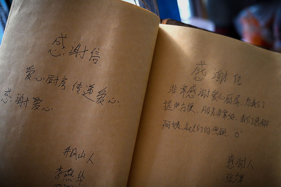 2021年3月25日，南昌，厨房墙壁上的留言册写满了患者家属对万佐成夫妇的感激。