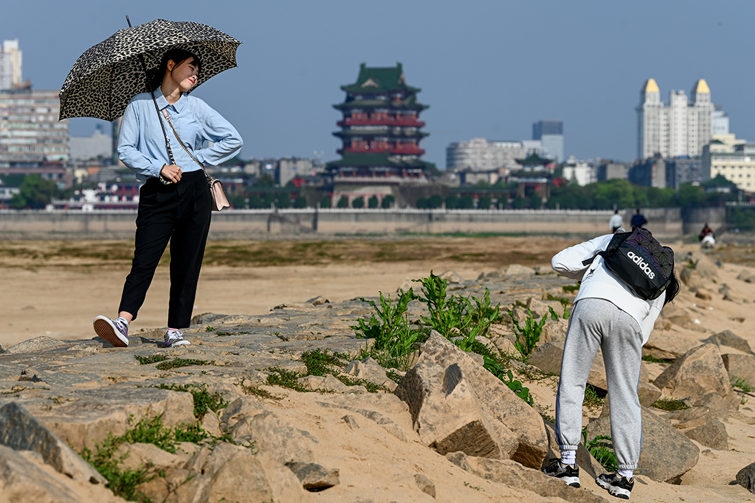 2021年3月28日，江西南昌，游客在赣江边拍照。