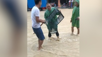 贵州平塘暴雨导致部分道路被淹，有市民在街头撒网捕鱼