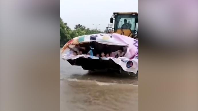 暴雨积水，河南新乡一幼儿园调来铲车护送孩子