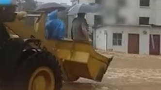 洪水太大无法步行，河南新乡医生坐铲车冒暴雨上班