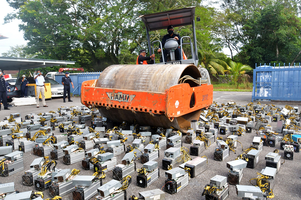 当地时间2021年7月16日，马来西亚美里，当地警方缴获大量比特币挖矿机，并在一次活动中用压路机销毁它们。