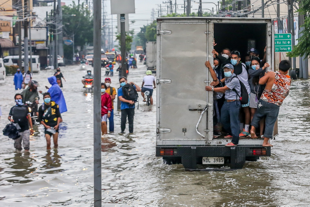 当地时间2021年7月24日，人们在菲律宾黎刹省乘车通过洪水泛滥的道路。由于近日持续遭遇强降雨，菲律宾多地发生洪涝灾害，超过1.5万人被疏散。 
