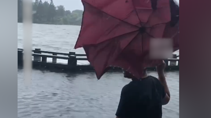 游客台风天逛西湖 这么大雨 我想感受一下