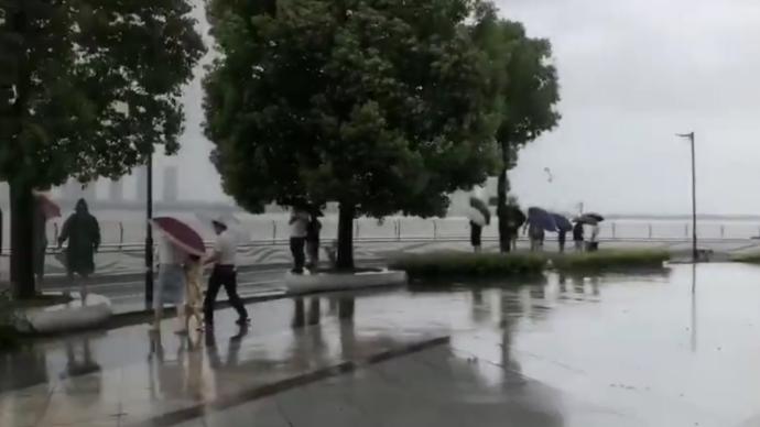 台风天钱塘江边仍有人看潮，现场拉起警戒线