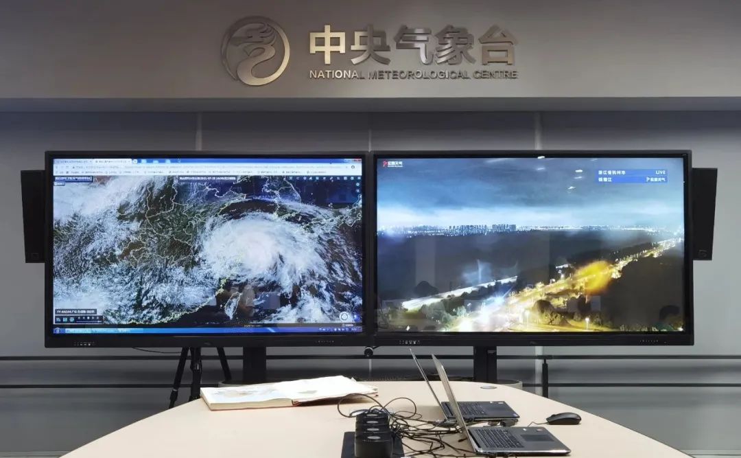 深夜的中央气象台,大屏幕上显示着云图和浙江省杭州市钱塘江实景图。 庄白羽 图