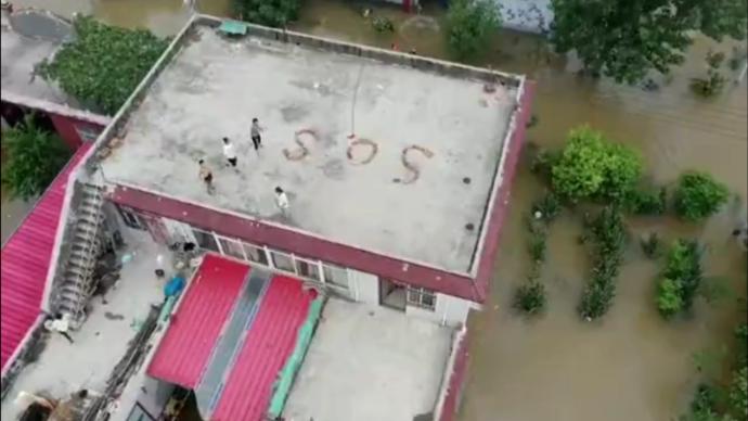 新乡村民被困楼顶2天摆出SOS，救援队航拍器拍到后救援