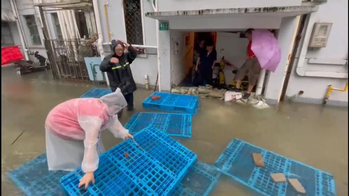 上海金山消防奔赴各小区紧急排水，小区居民用沙袋奋力自救