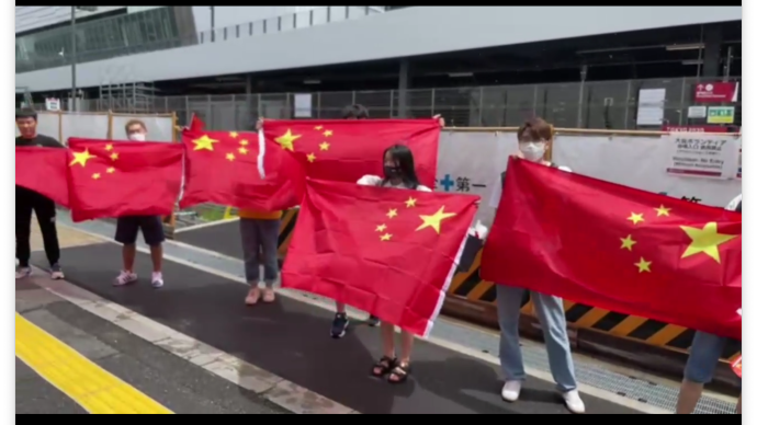 东京奥运中美女排焦点对决前，在日华人高举国旗助威加油