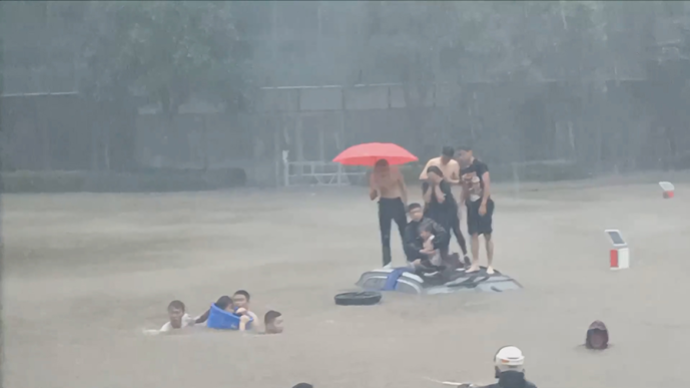 郑州暴雨中，他拍下砸车救人这一幕