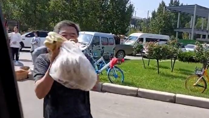 救援隊任務(wù)結(jié)束離開新鄉(xiāng)，大爺往車?yán)飶?qiáng)塞了一袋餅