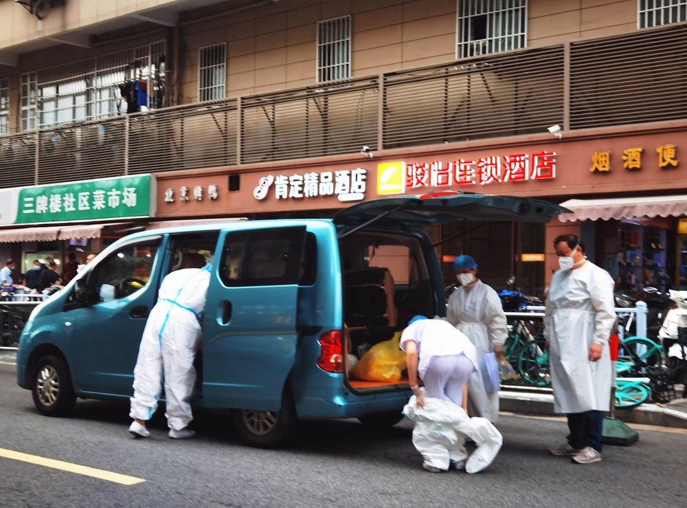 2021年7月28日,南京市,在三牌楼菜场一居民区,医护人员穿全身防护服,收集因为新冠疫情防控需要居家隔离人员的生活垃圾等物资。 视觉中国 图