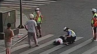 女子过马路时突然晕倒在地，执勤辅警和劝导员上前救助