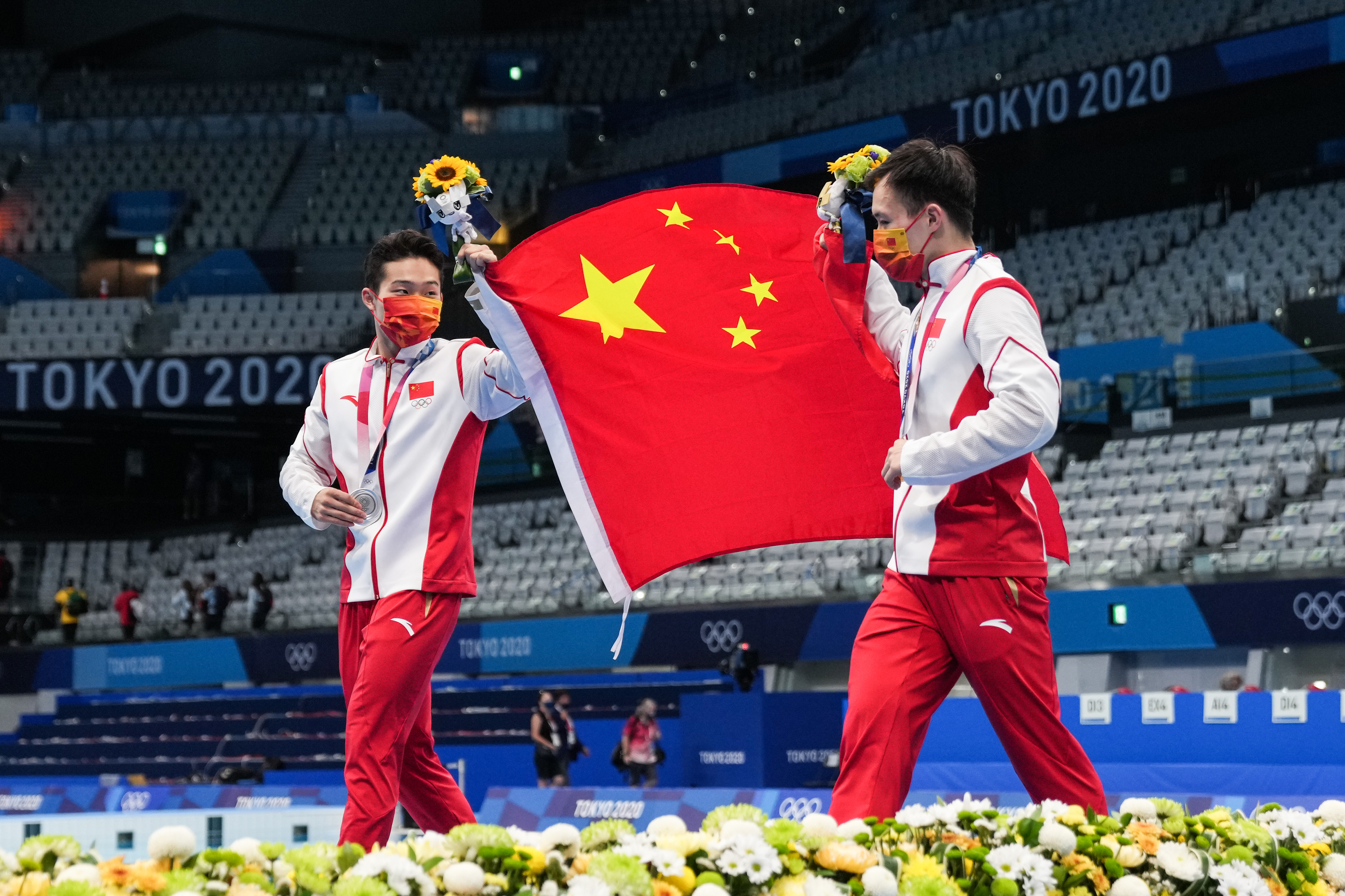 王宗源(左)和谢思埸手举国旗.